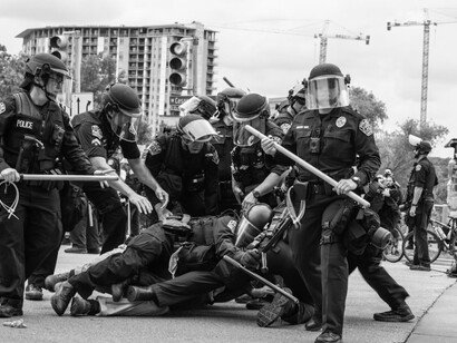 A group of police officers standing around a man on the ground