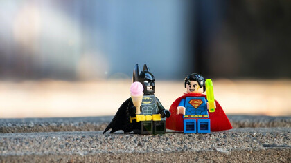 Superman and Batman action figures joined in friendship, holding hands