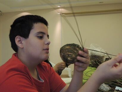 Niño aprendiendo a tejer cestas