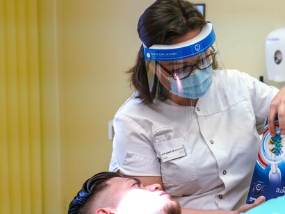Dentist showing patient a tooth brush head