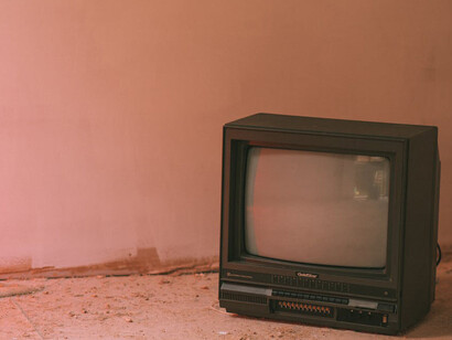 Vecchio televisore su pavimento in cemento di un edificio