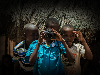Tres niños de Mozambique con cámara fotográfica