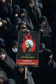 An Iranian woman holds up a poster showing Sheikh Nimr al-Nimr, a prominent opposition Saudi Shiite cleric who was executed last week by Saudi Arabia