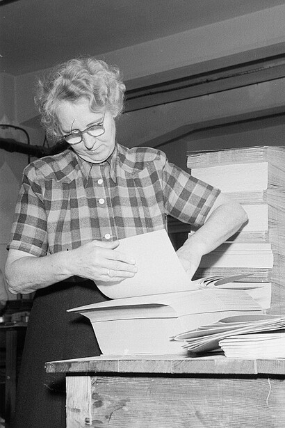 Secretaria revisando documentación en diversos archivos