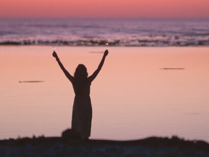 Against the breathtaking backdrop of a vibrant sunset, her cheerful walk symbolises the awakening of her spirit and the pursuit of her dreams
