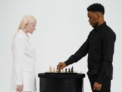 Two people engaged in a strategic game of chess, representing the deliberate process of testing ideas before reaching conclusions