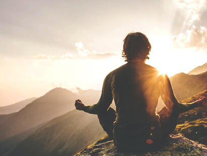 Hombre meditando en una montaña