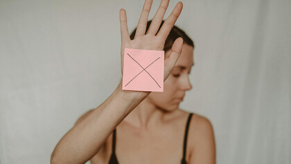 Una giovane donna posa per dire no alla violenza sulle donne