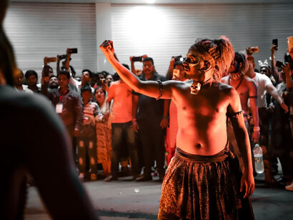 In Jodhpur, India, a man in a costume leads the Shiva dance while surrounded by an attentive group of people