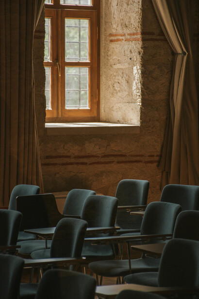 An empty conference room bathed in soft light, symbolizing the fading dialogue within the halls of academia