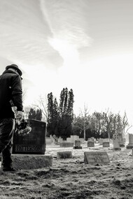 A person walking in a cemetery where the dead are buried but remembered 