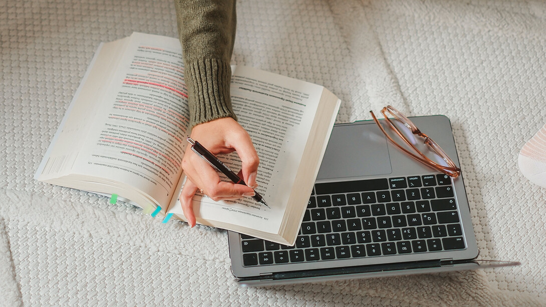 Mãos sublinham tópicos de um livro sobre como atingir metas pessoais ao começar um novo propósito de vida