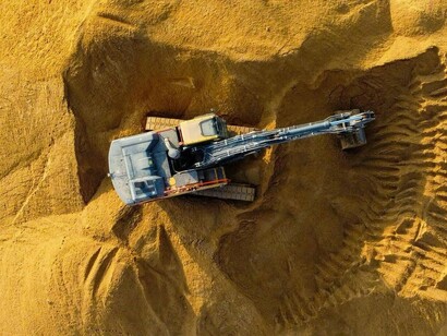 Excavation equipment stationed on a rising sand formation, symbolising the transformation of raw ground into buildable form