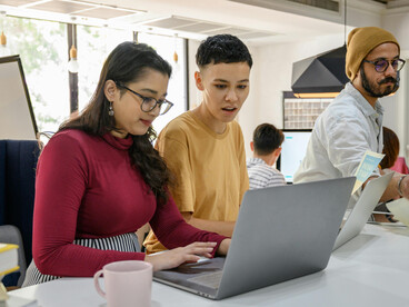 Creative technology team in a startup office discussing new ideas during a brainstorming session