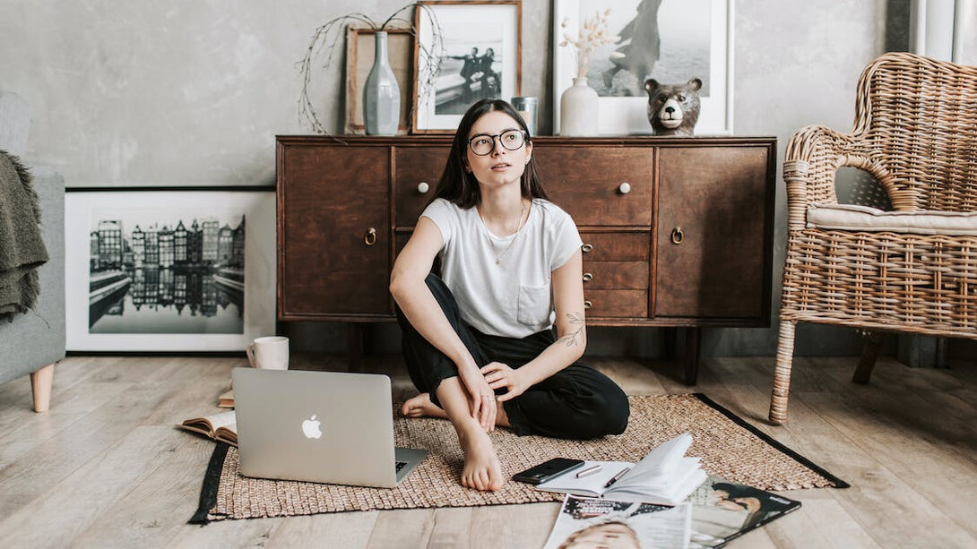 Mujer pensativa sentanda en medio del salón. El 'overthinking' es un estado mental: es pensar más de lo necesario sobre un asunto