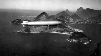 Dirigível LZ 127 "Graf Zeppelin" sobre o Rio de Janeiro. Estávamos todos juntos, minha mãe, meu pai, meus irmãos. Meus pais tinham me dado a permissão rara de andar um pouco mais longe, mas eu sabia que não podia ir muito além da barraca da pipoca. Ainda assim, minha curiosidade me empurrava, como sempre fazia
