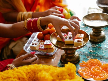 Hands busy arranging sweets and flowers, reflecting the harmony of tradition and celebration
