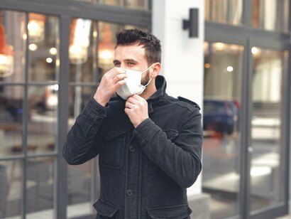 Homem coloca sua máscara para andar na rua