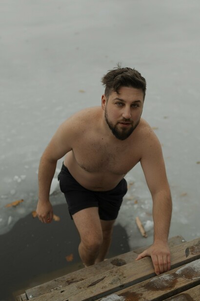 A man about to enter icy waters with a determined expression, illustrating the power of hormetic stress through cold exposure that activates the body's adaptive responses
