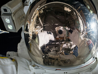 An astronaut hovers next to a satellite in orbit