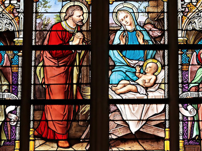 Stained glass art depicting the Holy Family graces the interior of a church