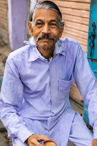Elderly man enjoying a cup of chai at a roadside tea stall in Jaipur, India