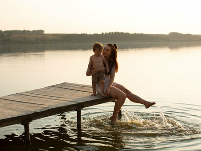 A woman and child on a dock gently disturbing the calm water at sunset beautifully capture the inner serenity and "beauty of being that can be found amidst life's chaos and challenges