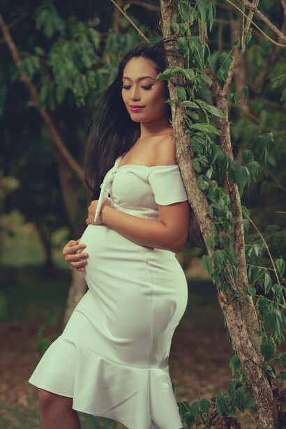 A woman poses while pregnant