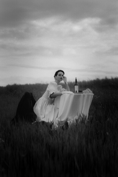 Black and white photo of a woman from South West France drinking a glass of Malbec wine in a field