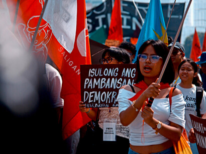 People in the Philippines protesting outdoors with colorful banners