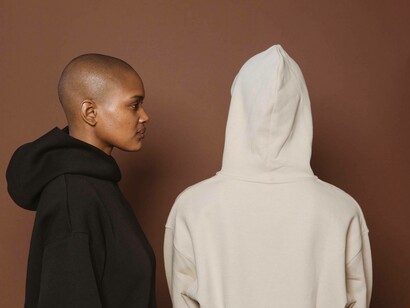 The person wearing the black hoodie faces the person wearing the white hoodie
