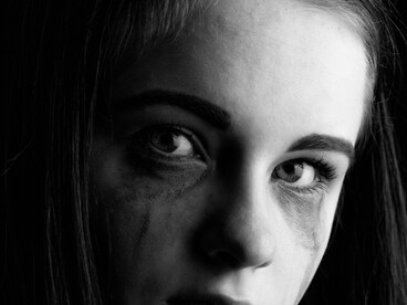 Black-and-white portrait of a crying girl, capturing the raw emotion of depression