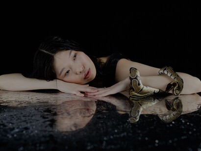 Mulher deitada com cobra no braço