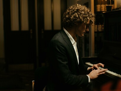 A man in a suit playing the piano 