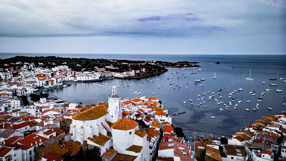 Fishing boats line the waterfront of Cadaqués, Spain, a charming Mediterranean village known for its whitewashed houses and coastal beauty