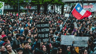 Citizens wave the Chilean flag during a mass demonstration, symbolizing national unity and rising civic engagement ahead of the upcoming election