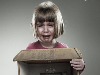 Niña llorando con un juguete en las manos