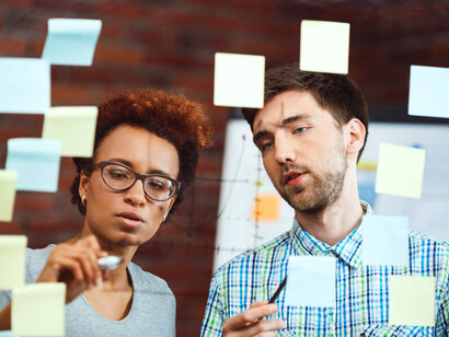 By organising their ideas on sticky notes, the duo is breaking down a complex problem into manageable components for more effective analysis