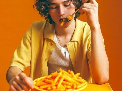 Menino comendo batatas fritas