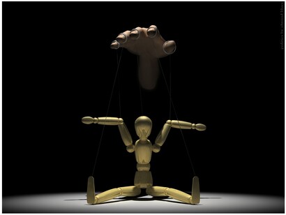 Una marioneta movida por una mano