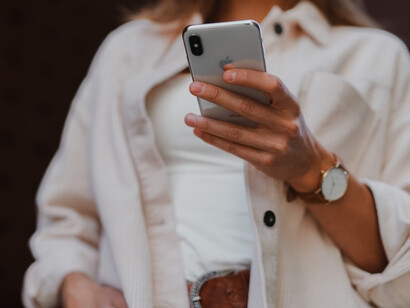Efficiently managing social media, a woman in a white coat deftly wields her phone