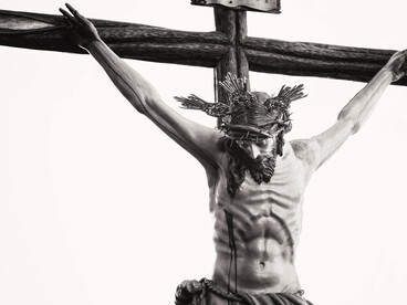 Grayscale image showing a detailed crucifix of Jesus inside a historic church in Carmona, Andalusia, Spain