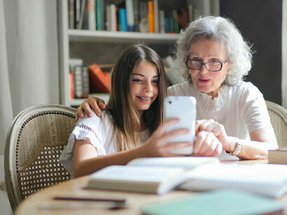 Grand-mère et petite-fille regardant un téléphone portable. Mercredi, comme chaque semaine, je me rends chez ma grand-mère pour déjeuner avec elle. Pour contextualiser, elle a 86 ans et est en fauteuil roulant © Sacha Jea