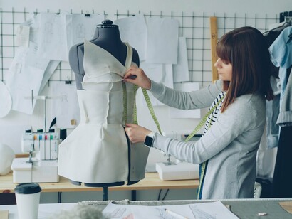 A fashion designer arranging and measuring fabric on a mannequin, symbolizing g how every piece of material can become part of an intentional design