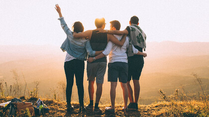 A tender embrace of friends under the sunset, reminding us that our strength often lies not in independence, but in the arms of those who never let us fall