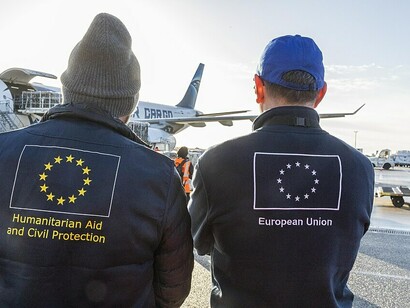 Members of the European Civil Protection and Humanitarian Aid Operations (ECHO) and the International Federation of Red Cross and Red Crescent Societies (IFRC) oversee the loading of humanitarian cargo destined for the people of Gaza, supporting relief efforts for communities affected by the ongoing crisis