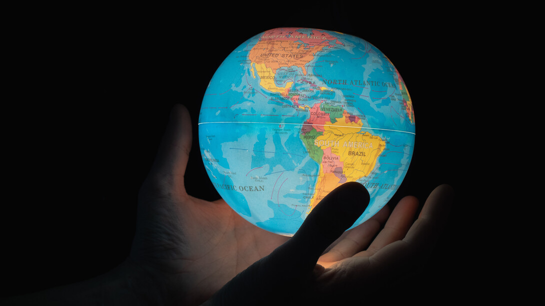 Manos sostienen un mapa mundi con luz interior