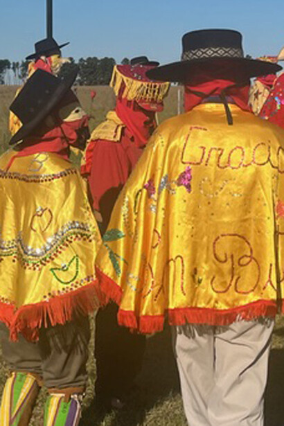 Fotografía: Milagros Andérica. Portan trajes muy coloridos hechos a mano en color rojo y amarillo. Se complementan con boinas, sombreros, capas y delantales bordados con apliques llamativos; canutillos de colores, lentejuelas y mucho brillo que hacen alusión a la vestimenta ostentosa que lleva un rey, Paraje Batel, a 40 kilómetros de la ciudad de Goya, Argentina