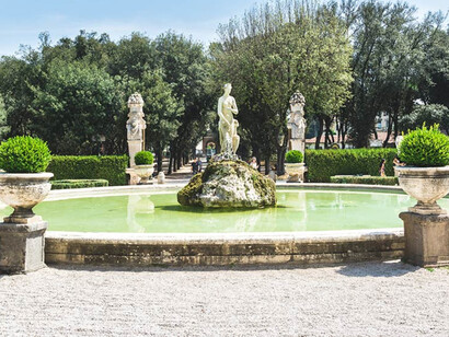 A water fountain, surrounded by statues and planters in the gardens of Villa Borghese Park, Rome, Italy