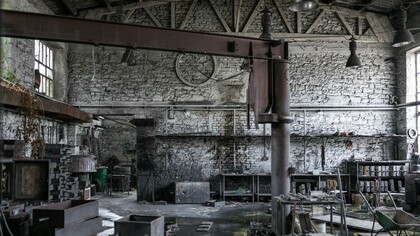 A forgotten factory space with high ceilings and exposed framework, representing the potential for converting industry into habitation